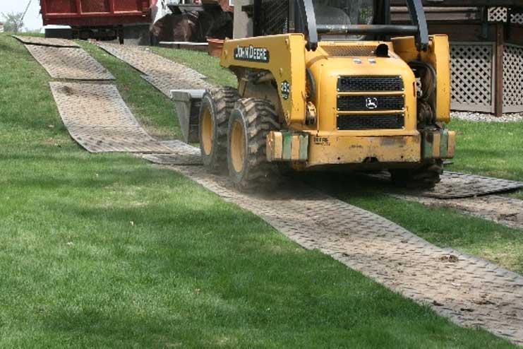 Truck mats being driven on by a large digger